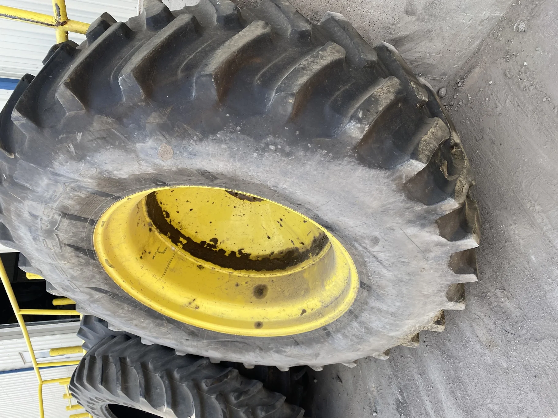 Used 70% 580/85R42 Firestone Radial Deep Tread 23 R-1W (166B) TL on a 18 x 42 JD Yellow 10 Bolt