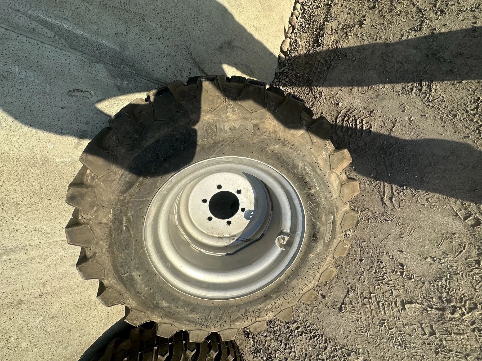 USED 95% 12-16.5 Titan Trac Loader NHS C(6Ply) TL on a 9.75 X 16.5 Silver Mist 6 Bolt Imp Wheel