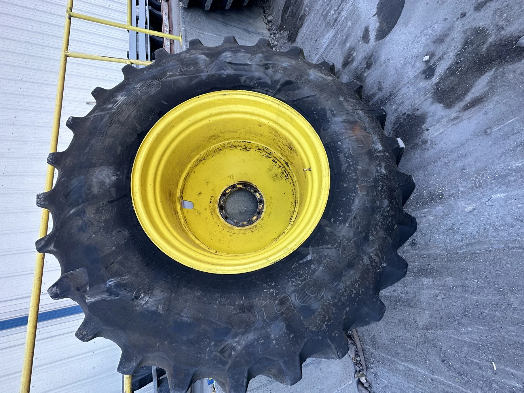 Used 80% 650/85R38 Firestone Radial Deep Tread 23 R-1W 173B TL on a 23 x 38 JD 10 Bolt Outside Dolly