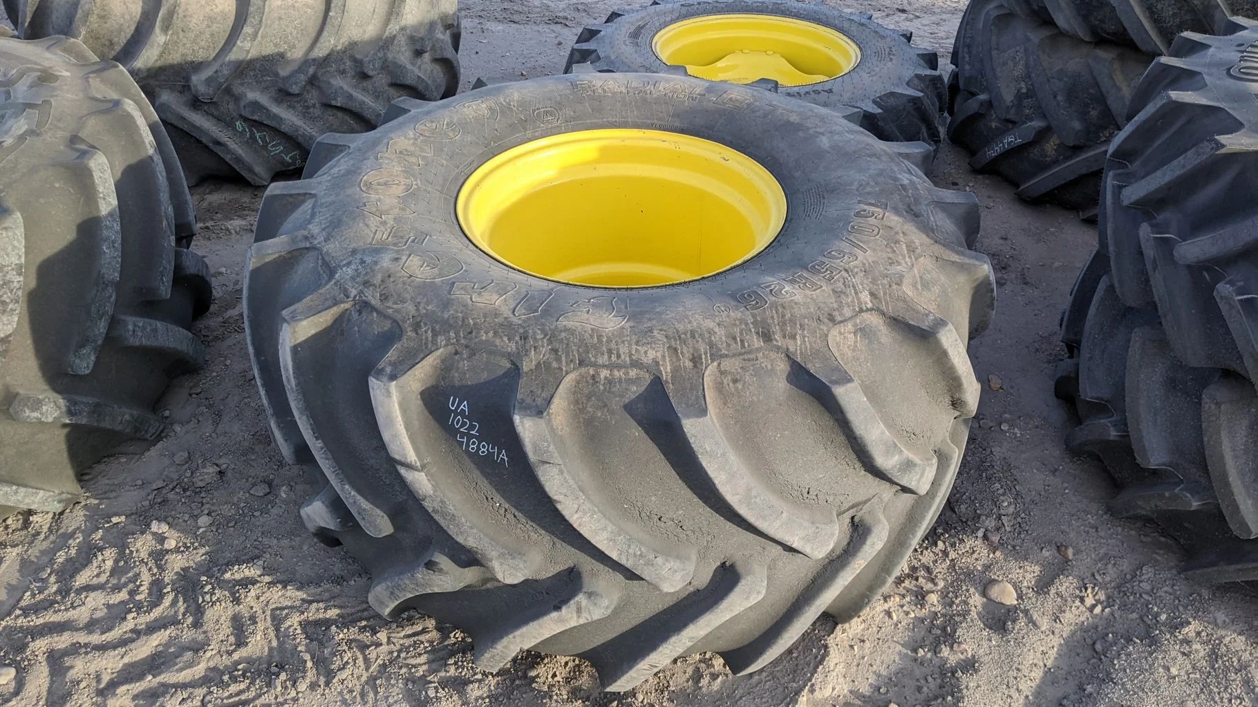 Used 80% 750/65R26 Firestone Radial All Traction DT R-1W (169B) TL on a 25 x 26 JD Yellow 8 Bo