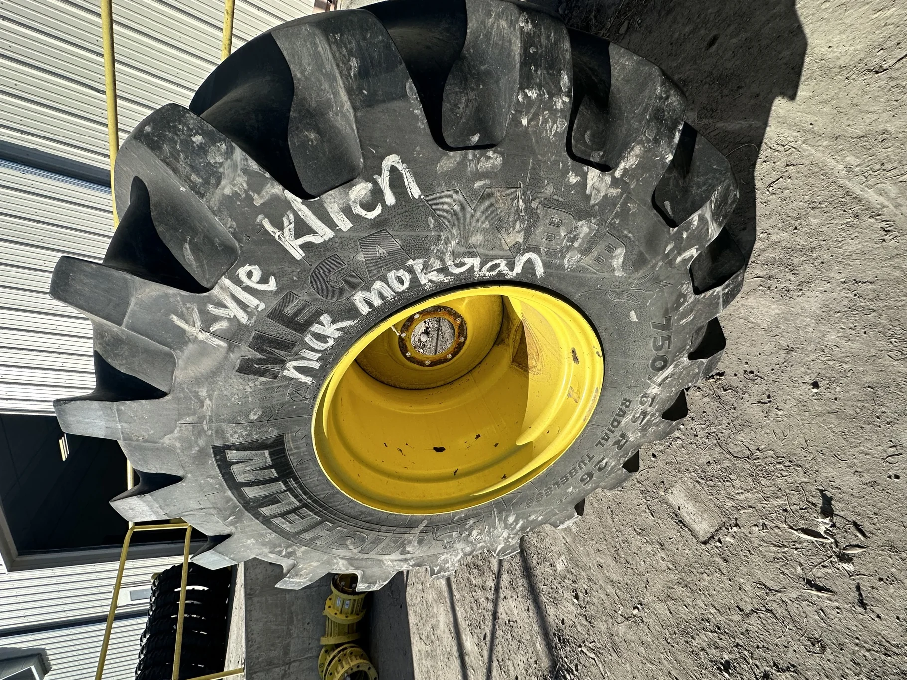 Used 70% 750/65R26 Michelin MegaXBib R-1W 171A8/171B TL on a 25 x 26 JD Yellow 8 Bolt Rear Com